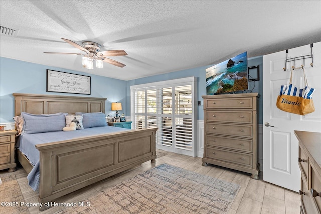 4387 6th Isle Dr, Hernando Beach, FL 34607 - bedroom with access to exterior, a textured ceiling, ceiling fan, and light wood-style floors