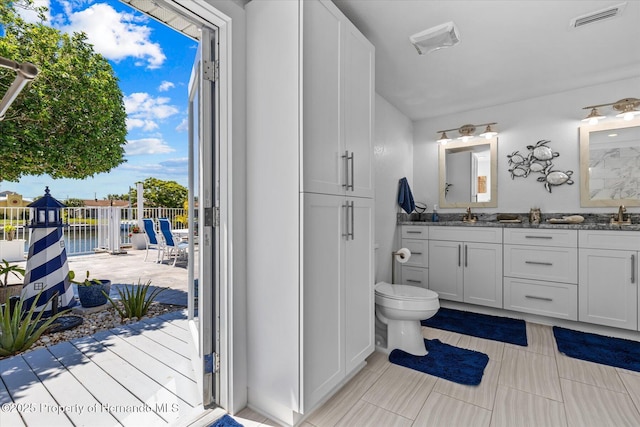 4387 6th Isle Dr, Hernando Beach, FL 34607 - full bathroom featuring toilet, double vanity, and tile patterned floors