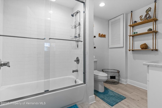 4387 6th Isle Dr, Hernando Beach, FL 34607 - bathroom featuring baseboards, toilet, wood finished floors, enclosed tub / shower combo, and vanity