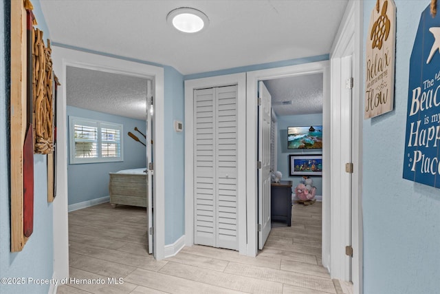 4387 6th Isle Dr, Hernando Beach, FL 34607 - corridor with a textured ceiling, wood finished floors, and baseboards