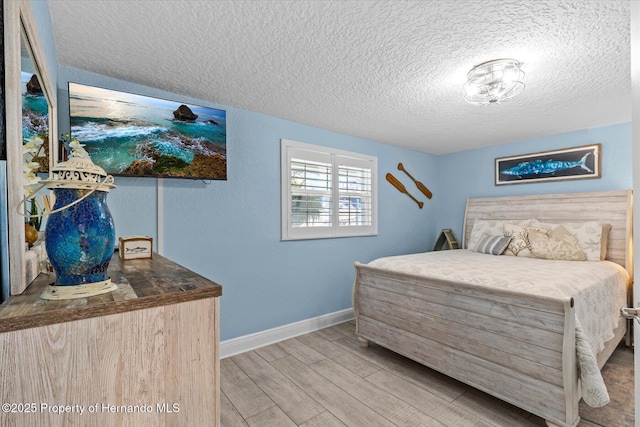 4387 6th Isle Dr, Hernando Beach, FL 34607 - bedroom featuring a textured ceiling, wood finished floors, and baseboards