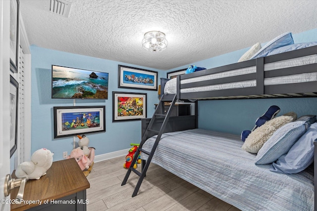 4387 6th Isle Dr, Hernando Beach, FL 34607 - bedroom with light wood-type flooring, baseboards, and a textured ceiling