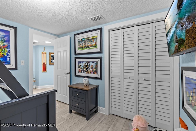 4387 6th Isle Dr, Hernando Beach, FL 34607 - bedroom featuring light wood-style flooring, a closet, a textured ceiling, and baseboards