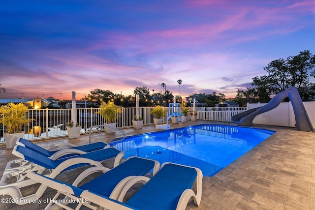 4387 6th Isle Dr, Hernando Beach, FL 34607 - pool at dusk with a water slide and a patio area