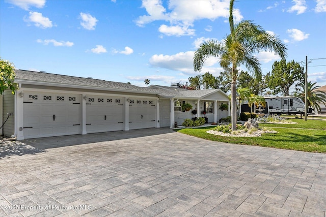 4387 6th Isle Dr, Hernando Beach, FL 34607 - ranch-style house featuring decorative driveway, a garage, a front lawn, and covered porch