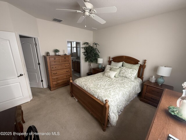 9238 Southern Charm Cir, Brooksville, FL 34613 - bedroom with light colored carpet, a ceiling fan, and ensuite bathroom