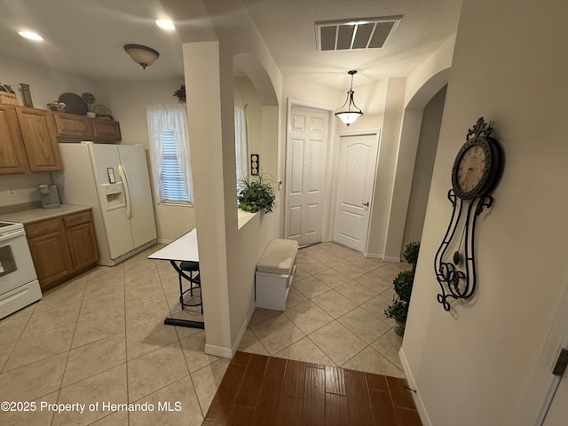 9238 Southern Charm Cir, Brooksville, FL 34613 - foyer with arched walkways, light tile patterned floors, and baseboards