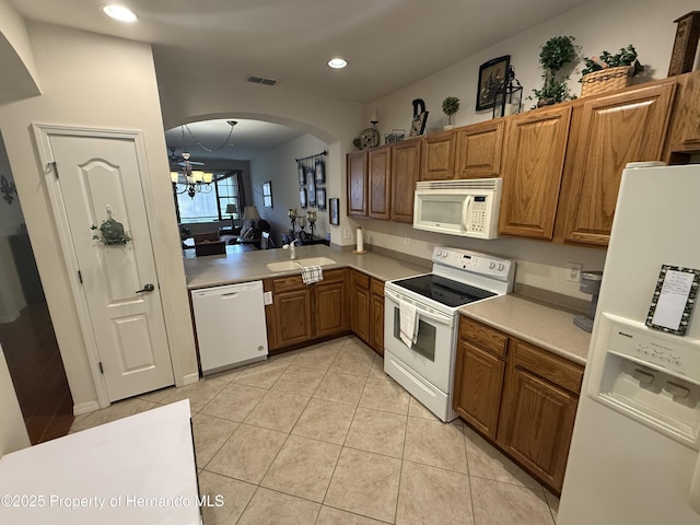9238 Southern Charm Cir, Brooksville, FL 34613 - kitchen with white appliances, a sink, brown cabinets, and recessed lighting