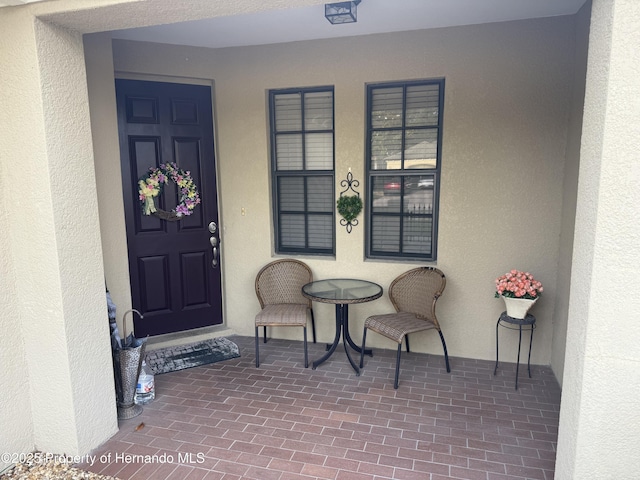 9238 Southern Charm Cir, Brooksville, FL 34613 - view of exterior entry featuring stucco siding and a porch