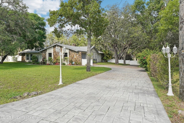 18633 Oak Way Dr, Hudson, FL 34667 - mid-century modern home featuring decorative driveway, a chimney, and stone siding