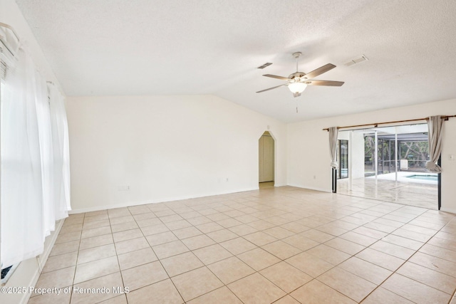 18633 Oak Way Dr, Hudson, FL 34667 - empty room with a ceiling fan, lofted ceiling, light tile patterned flooring, a textured ceiling, and baseboards