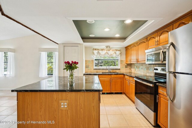 18633 Oak Way Dr, Hudson, FL 34667 - kitchen with stainless steel appliances, a sink, light tile patterned flooring, a tray ceiling, and recessed lighting