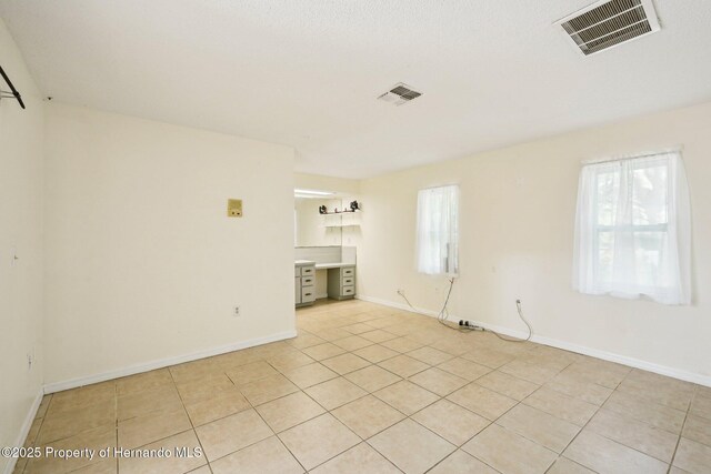 18633 Oak Way Dr, Hudson, FL 34667 - spare room with light tile patterned flooring and baseboards