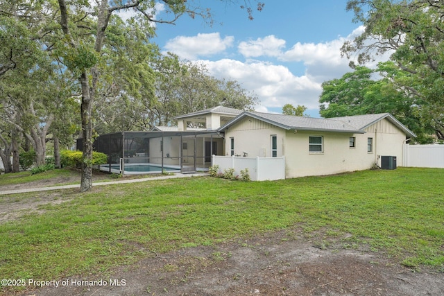 18633 Oak Way Dr, Hudson, FL 34667 - view of front of home featuring central air condition unit, an outdoor pool, a lanai, stucco siding, and a sunroom