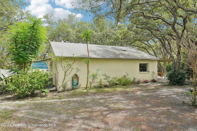 18633 Oak Way Dr, Hudson, FL 34667 - view of property exterior with stucco siding and roof with shingles