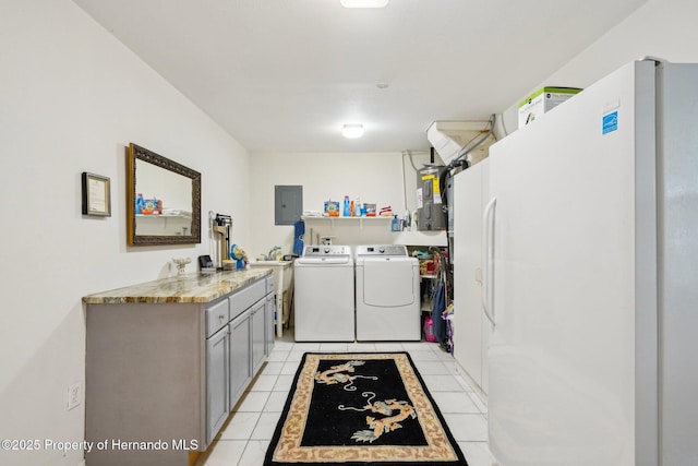 18633 Oak Way Dr, Hudson, FL 34667 - laundry room with washing machine and clothes dryer, electric panel, cabinet space, and light tile patterned floors