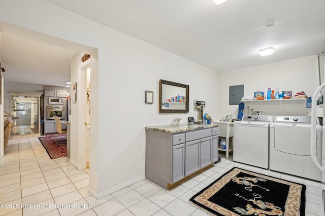 18633 Oak Way Dr, Hudson, FL 34667 - laundry room with washer and clothes dryer, electric panel, light tile patterned flooring, baseboards, and cabinet space