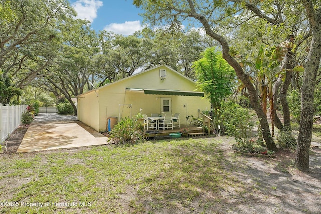 18633 Oak Way Dr, Hudson, FL 34667 - back of property with stucco siding, a wooden deck, and a patio