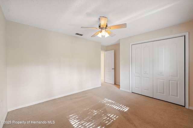 10296 Palmgren Ln, Spring Hill, FL 34608 - unfurnished bedroom with carpet flooring, a closet, baseboards, and a ceiling fan
