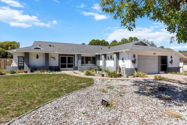 10267 Elgin Blvd, Spring Hill, FL 34608 - back of property featuring a garage, concrete driveway, brick siding, a yard, and roof with shingles