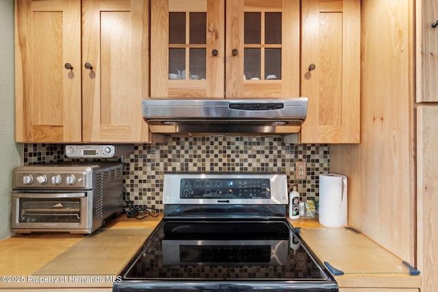 10267 Elgin Blvd, Spring Hill, FL 34608 - kitchen with stainless steel electric range oven, range hood, light brown cabinetry, and light countertops
