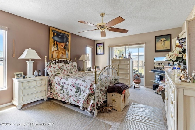 10267 Elgin Blvd, Spring Hill, FL 34608 - bedroom with carpet, a textured ceiling, access to exterior, a ceiling fan, and baseboards
