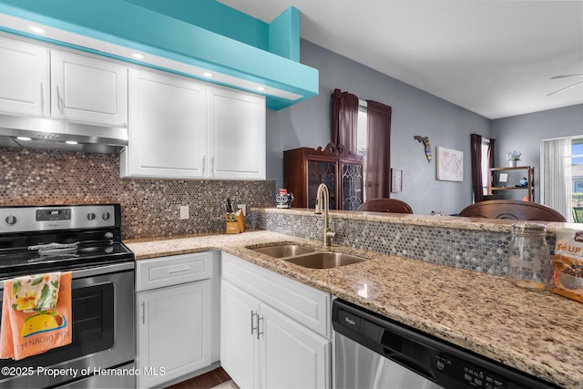 9407 Burnam Dr, Weeki Wachee, FL 34613 - kitchen featuring appliances with stainless steel finishes, extractor fan, a sink, white cabinetry, and decorative backsplash