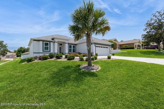 224 W Rexford Dr, Beverly Hills, FL 34465 - view of front facade featuring driveway, a garage, a front yard, and stucco siding
