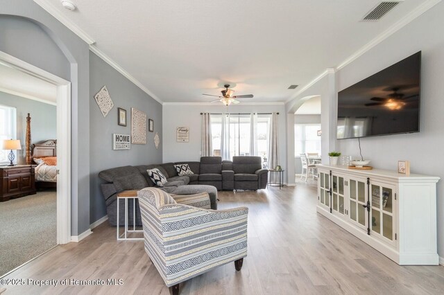 224 W Rexford Dr, Beverly Hills, FL 34465 - living room with arched walkways, ceiling fan, light wood-style floors, ornamental molding, and baseboards