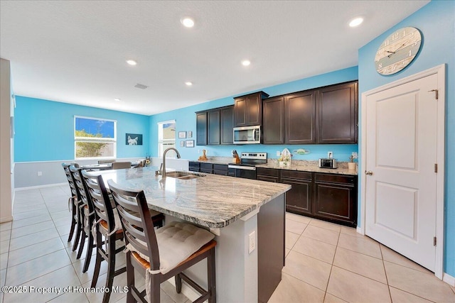 13454 Golden Lime Ave, Spring Hill, FL 34609 - kitchen featuring a sink, appliances with stainless steel finishes, light tile patterned floors, a kitchen breakfast bar, and recessed lighting