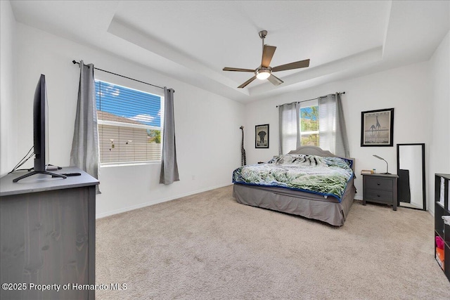 13454 Golden Lime Ave, Spring Hill, FL 34609 - carpeted bedroom with a tray ceiling, baseboards, and ceiling fan