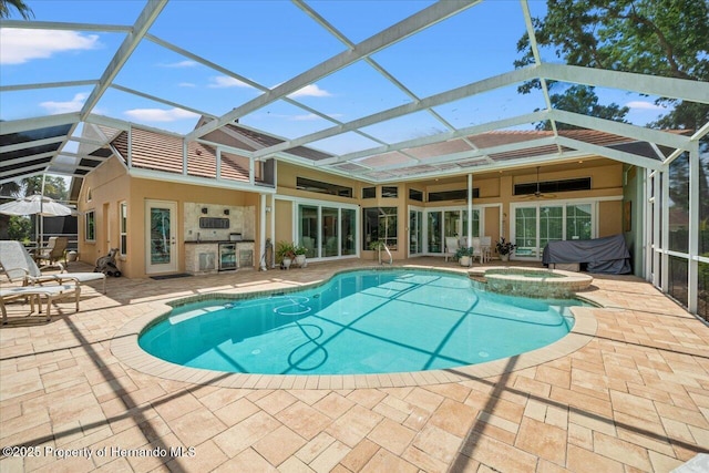 9161 Southern Comfort Ct, Weeki Wachee, FL 34613 - view of pool with a patio area, glass enclosure, a pool with connected hot tub, and an outdoor kitchen