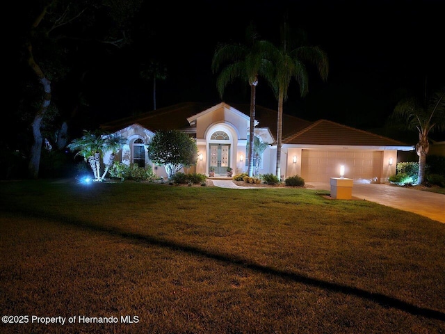 9161 Southern Comfort Ct, Weeki Wachee, FL 34613 - view of front of property featuring french doors, a garage, a lawn, and concrete driveway