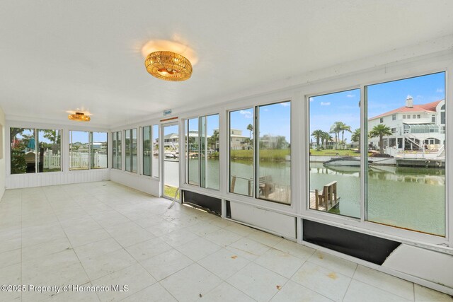 3226 Gardenia Dr, Hernando Beach, FL 34607 - unfurnished sunroom featuring a water view, tile patterned flooring, and plenty of natural light