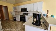 455 Cressida Cir, Spring Hill, FL 34609 - kitchen featuring stainless steel range with electric cooktop, light countertops, and white cabinetry