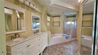 455 Cressida Cir, Spring Hill, FL 34609 - bathroom with double vanity, a bath, and a shower with door