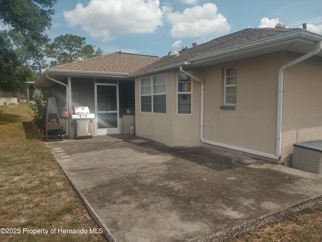 12132 Norvell Rd, Spring Hill, FL 34609 - rear view of house featuring stucco siding, a patio, and roof with shingles