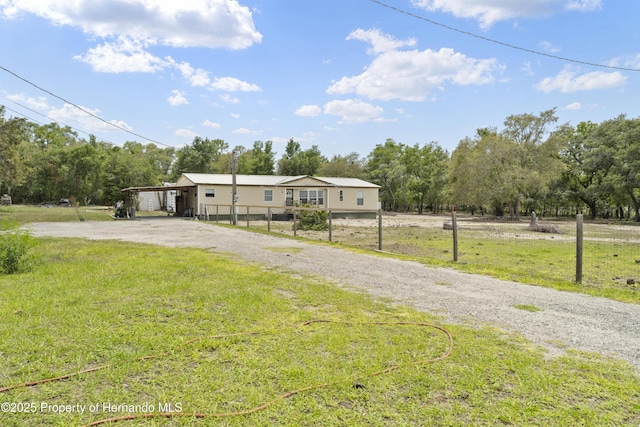 16040 Platinum Dr, Spring Hill Pasco, FL 34610 - manufactured / mobile home with driveway, a front yard, a carport, view of scattered trees, and a rural view