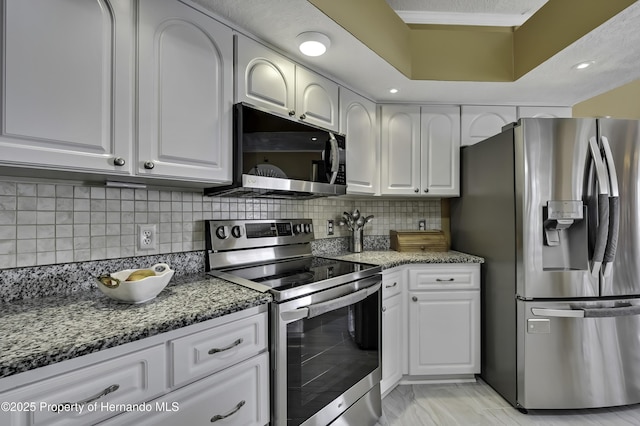 1086 Hook Dr, Spring Hill, FL 34608 - kitchen featuring appliances with stainless steel finishes, stone counters, white cabinets, and tasteful backsplash