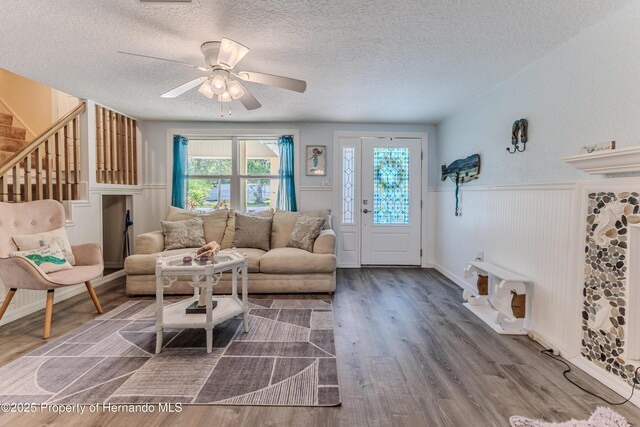 5507 Darlene St, Weeki Wachee, FL 34607 - living room with a textured ceiling, wood finished floors, wainscoting, stairway, and ceiling fan