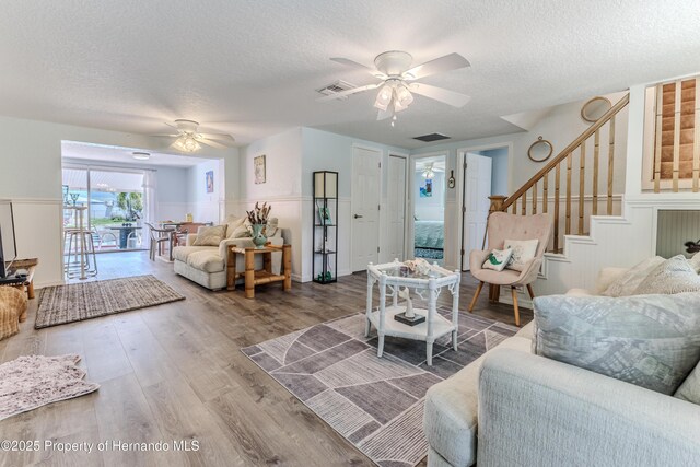 5507 Darlene St, Weeki Wachee, FL 34607 - living area with a ceiling fan, stairway, a textured ceiling, wood finished floors, and wainscoting