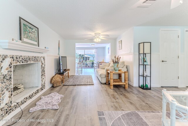 5507 Darlene St, Weeki Wachee, FL 34607 - living room with a ceiling fan, wood finished floors, wainscoting, and a fireplace