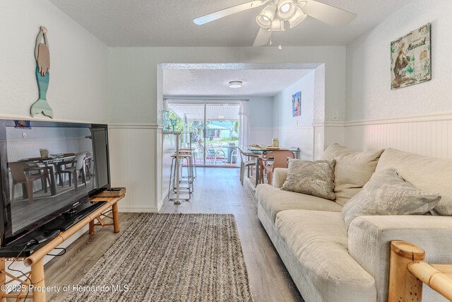 5507 Darlene St, Weeki Wachee, FL 34607 - living area featuring wainscoting, wood finished floors, and ceiling fan