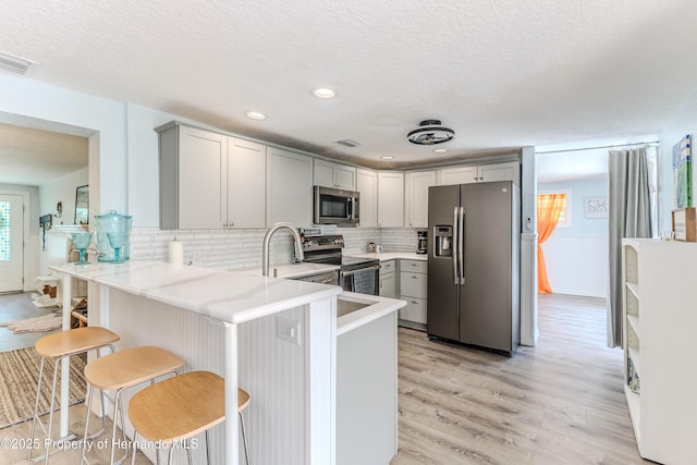 5507 Darlene St, Weeki Wachee, FL 34607 - kitchen featuring stainless steel appliances, gray cabinets, light wood-style floors, light countertops, and a textured ceiling