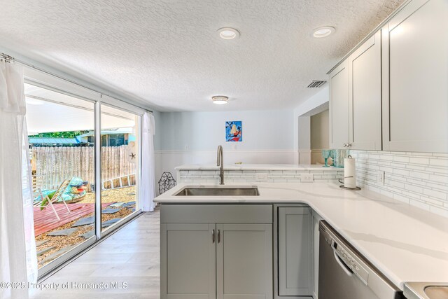 5507 Darlene St, Weeki Wachee, FL 34607 - kitchen featuring a textured ceiling, a sink, dishwasher, gray cabinetry, and light countertops