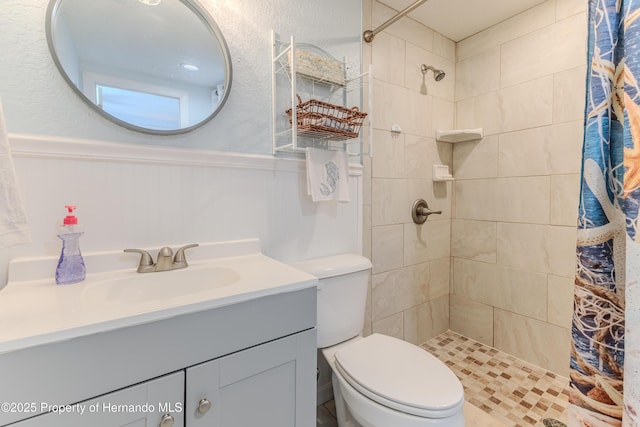 5507 Darlene St, Weeki Wachee, FL 34607 - bathroom featuring tiled shower, vanity, toilet, and a wainscoted wall