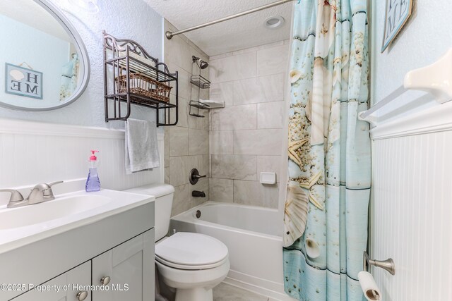 5507 Darlene St, Weeki Wachee, FL 34607 - bathroom featuring shower / tub combo, a wainscoted wall, vanity, a textured ceiling, and toilet