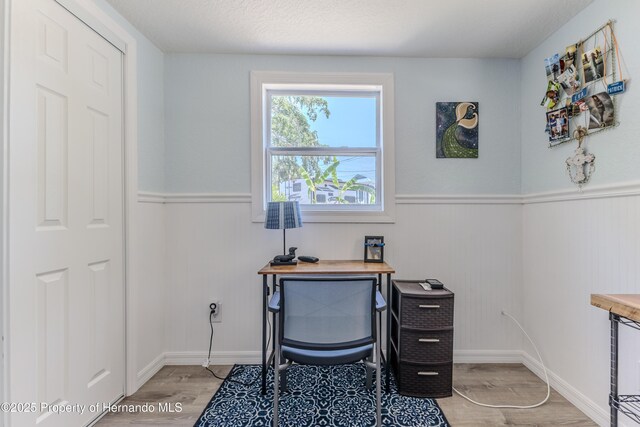 5507 Darlene St, Weeki Wachee, FL 34607 - home office with light wood-style flooring, wainscoting, and baseboards