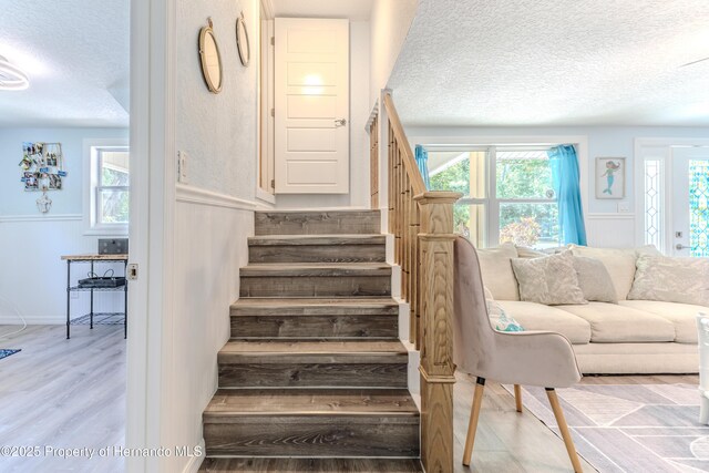 5507 Darlene St, Weeki Wachee, FL 34607 - stairs with a textured ceiling, wainscoting, and wood finished floors