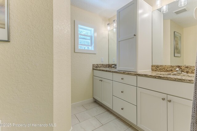 5507 Darlene St, Weeki Wachee, FL 34607 - full bathroom featuring a textured wall, double vanity, and tile patterned floors